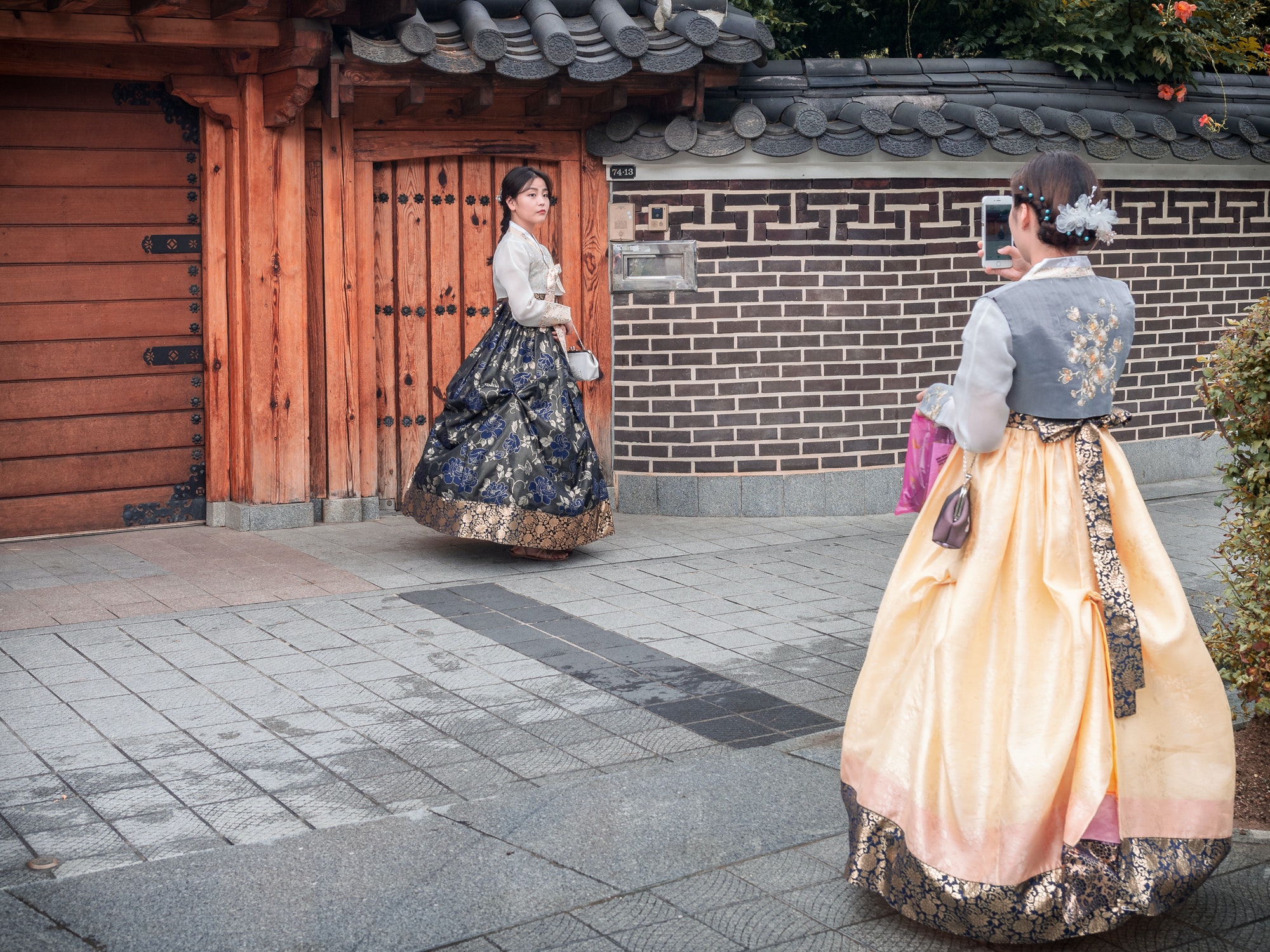 Jeonju, South Korea - August, 05 2017: Woman taking photo of friend in traditional Korean clothes